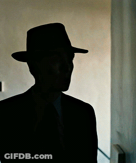 A Silhouette Of A Man In A Hat And Suit GIF