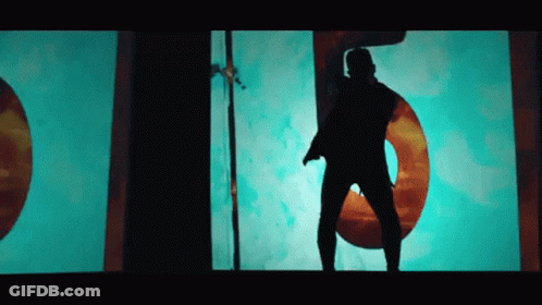 A Silhouette Of A Man Is Dancing In Front Of A Large Number 5 GIF