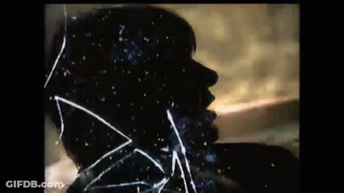 A Silhouette Of A Man 'S Face Is Behind A Broken Glass . GIF
