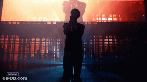 A Silhouette Of A Man Singing Into A Microphone With The Words Coachella On The Bottom GIF