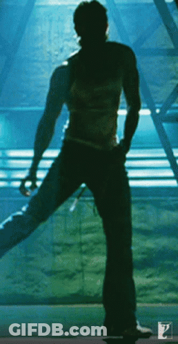 A Silhouette Of A Man Standing In Front Of A Blue Wall GIF