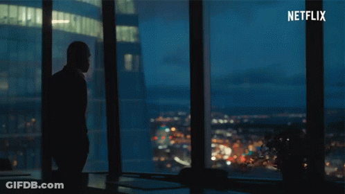 A Silhouette Of A Man Standing In Front Of A Window With Netflix Written In The Corner GIF