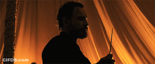 A Silhouette Of A Man With A Beard Is Holding A Wand GIF