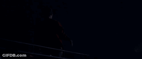 A Silhouette Of A Man With His Arms Outstretched Against A Dark Blue Sky GIF