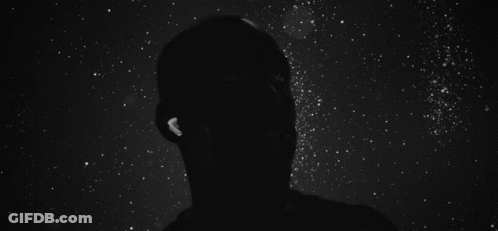 A Silhouette Of A Person Falling Into The Water Surrounded By White Particles On A Black Background . GIF