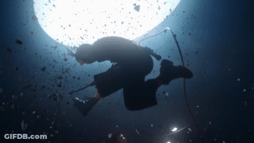 A Silhouette Of A Person Holding A Microphone Underwater GIF