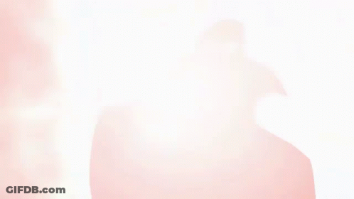 A Silhouette Of A Person In A Cape Is Against A Red Background GIF