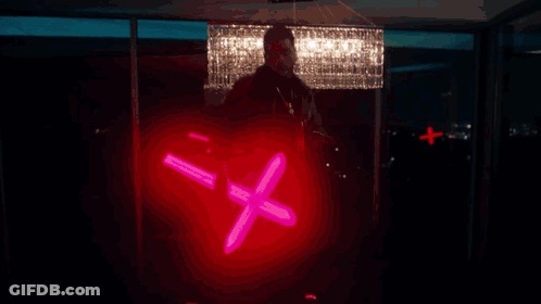 A Silhouette Of A Person In A Dark Room With A Blue Light Behind Him GIF