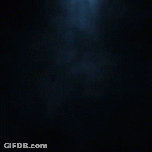 A Silhouette Of A Person In A Dark Room With A Hood GIF