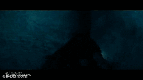 A Silhouette Of A Person In A Dark Room With A Light Coming Out Of The Ceiling . GIF