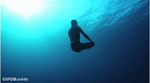 A Silhouette Of A Person Is Floating In The Water GIF