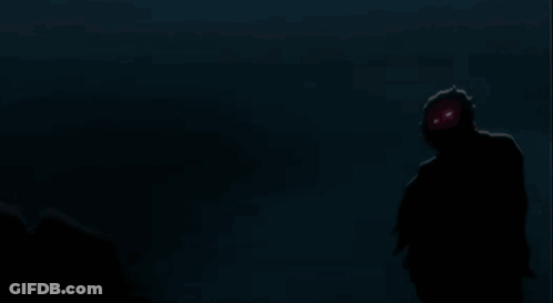 A Silhouette Of A Person Standing In The Dark With A Gray Background GIF