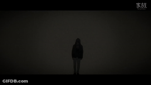 A Silhouette Of A Person Standing In The Dark With A Hood On . GIF