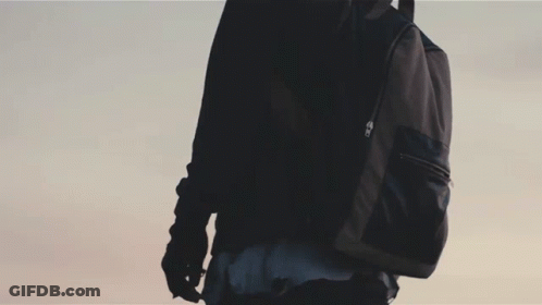 A Silhouette Of A Person Standing On Top Of A Wall With A Blue Sky In The Background GIF