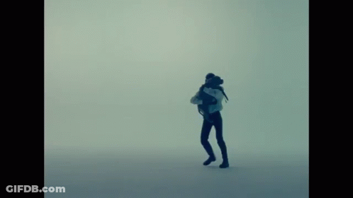 A Silhouette Of A Person With A Backpack Standing In The Fog GIF
