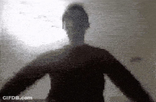 A Silhouette Of A Person With Their Arms Outstretched Against A Wall GIF
