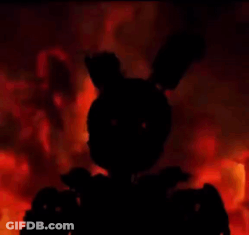 A Silhouette Of A Rabbit Is Standing In Front Of A Fire In The Dark . GIF