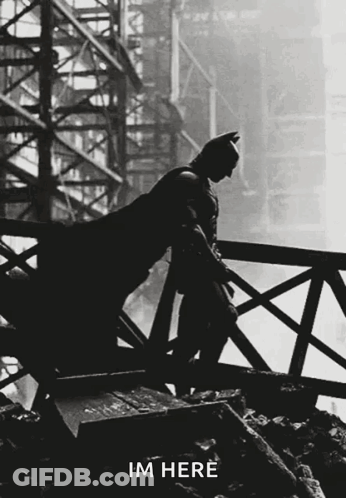 A Silhouette Of Batman Leaning On A Railing With The Words Im Here Written Below Him GIF