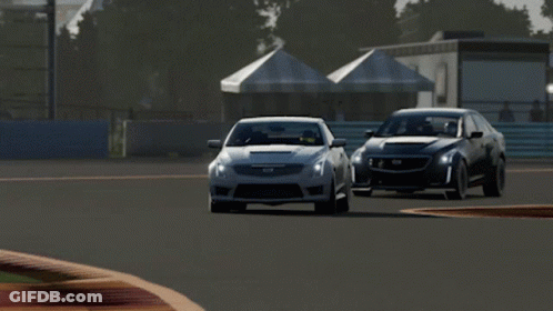 A Silver Cadillac Driving On A Race Track GIF
