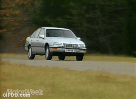 A Silver Car Is Driving Down A Road With Motorweek Written On The Bottom Right GIF