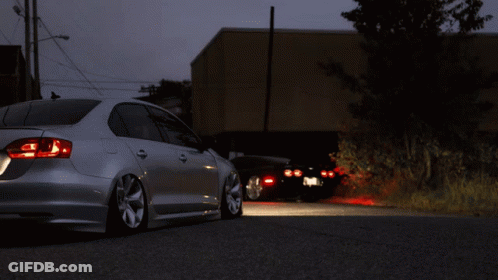 A Silver Car Is Parked On The Side Of A Road GIF