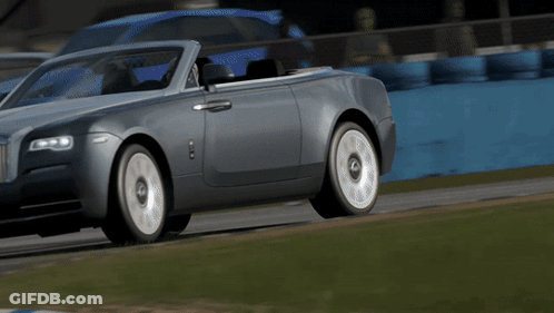 A Silver Convertible Rolls Royce Driving On A Track GIF