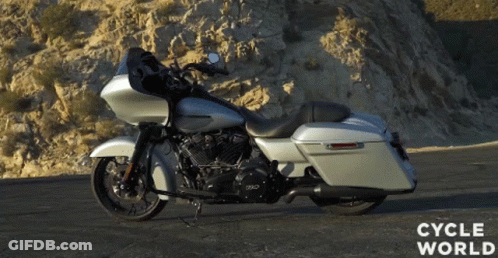 A Silver Harley Davidson Motorcycle Is Parked On A Road GIF