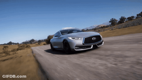 A Silver Infiniti Is Driving Down A Road With Mountains In The Background GIF