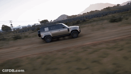 A Silver Land Rover Is Driving On A Dirt Road GIF