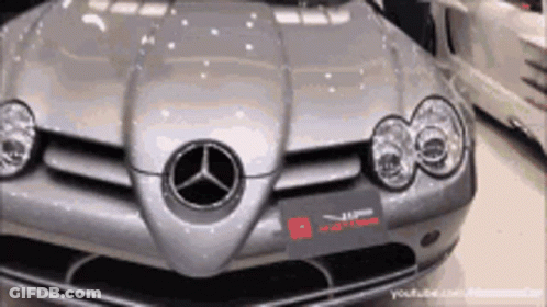 A Silver Mercedes Is Parked In A Garage With Other Cars GIF