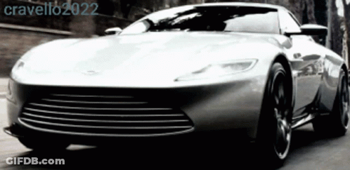 A Silver Sports Car Is Driving Down A Road With The Year 2022 On The Bottom Right GIF