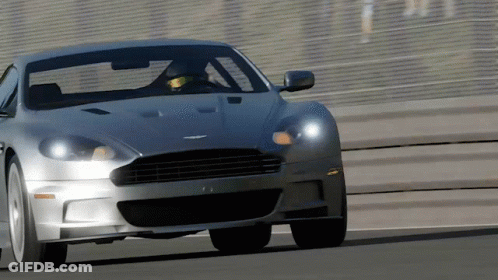 A Silver Sports Car Is Driving On A Road GIF