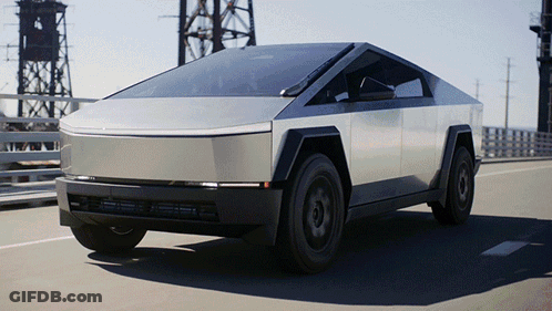 A Silver Tesla Cybertruck Is Driving Down A Bridge GIF