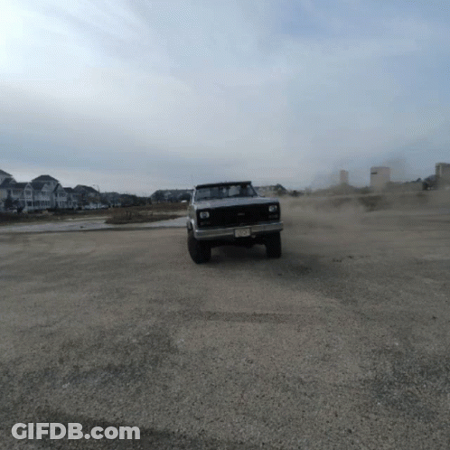 A Silver Truck With A New Jersey License Plate Is Driving Through A Dirt Field GIF