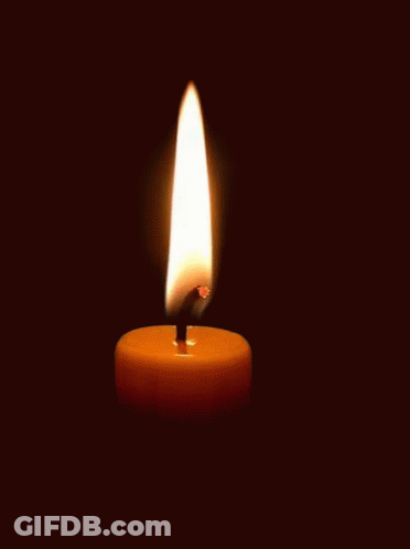 A Single Candle Is Lit In The Dark With A Black Background GIF