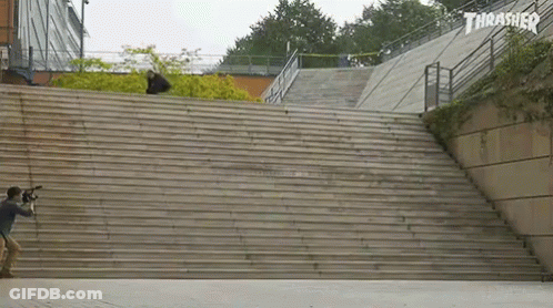A Skateboarder Is Doing A Trick On A Set Of Stairs With A Thrasher Logo Behind Him GIF