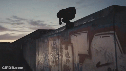 A Skateboarder Is Doing A Trick On Top Of A Wall That Has Graffiti On It Including The Letters Sb GIF