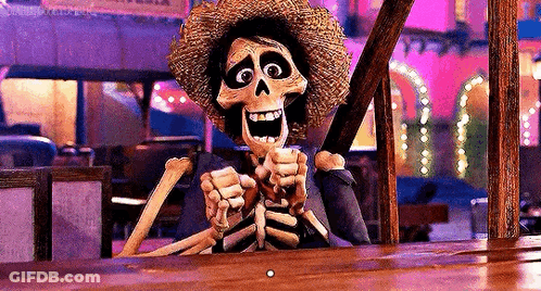 A Skeleton In A Straw Hat Is Sitting At A Table Holding A Stick . GIF