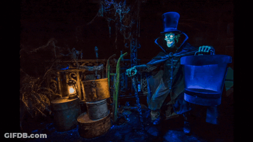 A Skeleton In A Top Hat Holding A Bucket In A Dark Room GIF