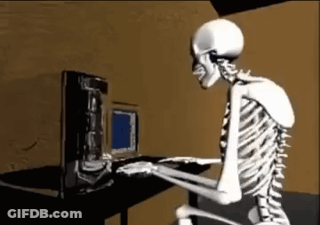 A Skeleton Is Sitting At A Desk Typing On A Computer . GIF