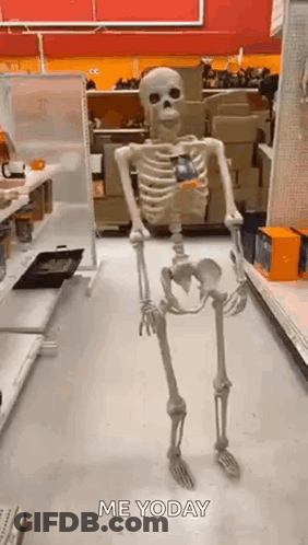 A Skeleton Is Standing In A Store Holding A Candy Bar . GIF