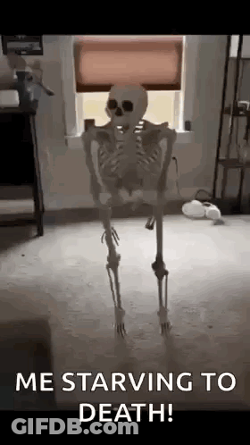 A Skeleton Is Standing In Front Of A Window With The Words `` Me Starving To Death '' Written On It . GIF