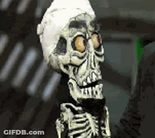 A Skeleton Wearing A Bandage On Its Head Is Holding A Microphone . GIF