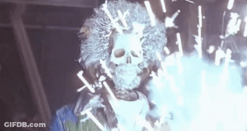 A Skeleton With A Wig And A Skull On His Head Is Surrounded By Sparklers . GIF