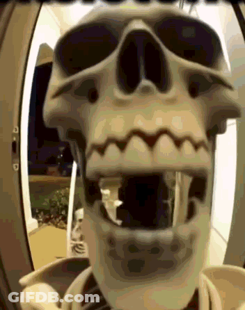 A Skeleton With Its Mouth Open Is Standing In A Doorway GIF