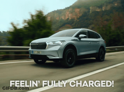A Skoda Car Is Driving Down A Road With The Words Feelin ' Fully Charged Behind It GIF
