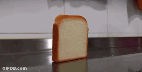A Slice Of Bread Is Sitting On A Counter In Front Of A Wall . GIF