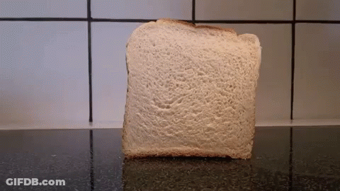 A Slice Of Bread Sits On A Counter In Front Of A White Tiled Wall GIF