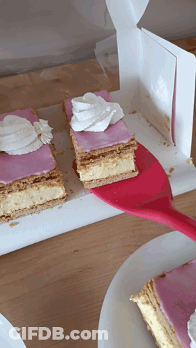 A Slice Of Cake With Pink Frosting And Whipped Cream On Top GIF