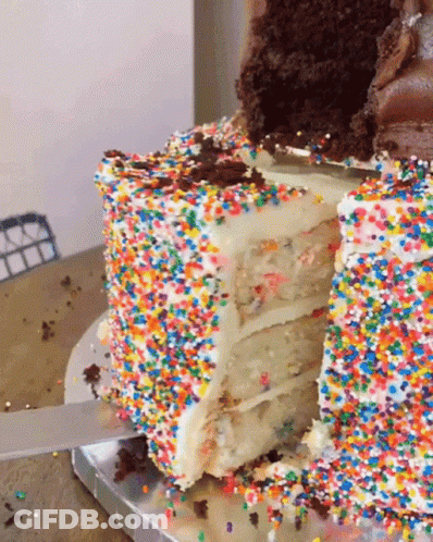 A Slice Of Cake With Sprinkles On It Is Being Cut GIF